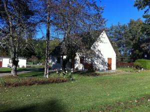ein weißes Haus mit Bäumen vor einem Hof in der Unterkunft La chataîgneraie 
