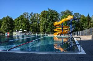 - une piscine avec un toboggan jaune dans l'établissement Familienbauernhof Köss Schertler, à Egg