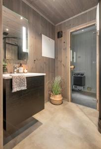 una cucina con pareti in legno e un bancone con una pianta di Exclusive Nordic Apartment with Sauna - Prime Location at Stranda near Geiranger a Stranda