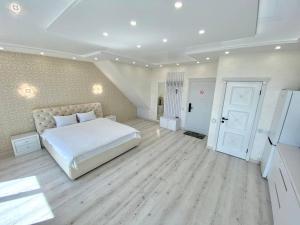 a large bedroom with a white bed and wooden floors at Кращі панорамні квартири Sky House в центрі Вінниці Безключовий доступ! in Vinnytsya