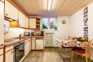 a kitchen with a table and a dining room at Ferienwohnung Berghansenhof in Wolfach