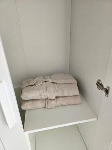 armadio bianco con asciugamano su una mensola di L'infini Sea View apartments Zubovići a Zubovići