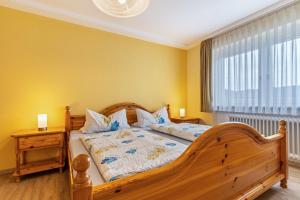 ヴォルフアッハにあるFerienwohnung Berghansenhofのベッドルーム1室(木製ベッド1台、窓付)