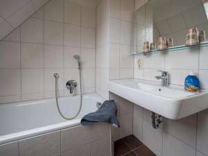 a white bathroom with a sink and a shower at Alte Wäscherei in Spiekeroog +17 photos
