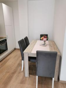 a dining room table with chairs and a vase of flowers at Apartman Juric in Posušje