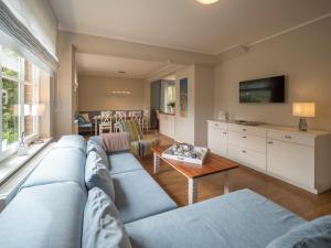 a living room with a blue couch and a table at Spiekerhorst in Spiekeroog