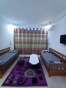a room with two beds and a tv in it at adel vacation in Djerba