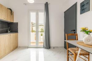 a kitchen with a table and a glass door at Fysalida's Coastal Gem 4 - Steps Away from the Sea in Heraklion +3 photos