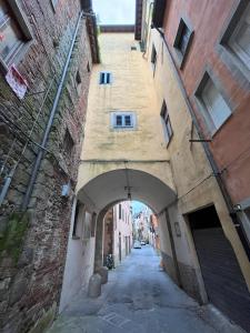 un callejón entre dos edificios con un arco en I due Ciueli en Pescia