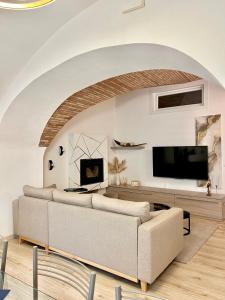 a living room with a couch and a flat screen tv at L’Arco sul Lago • Gold Apartment in Castro +23 photos
