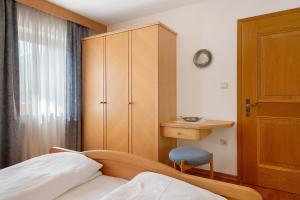 um quarto com uma cama, um armário e uma cadeira em Mayr Apartments Fünf em Plaus