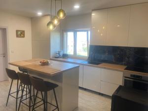 a kitchen with white cabinets and a wooden counter top at Apartman Telar in Vodice