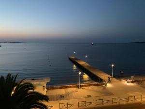 un quai au milieu de l'eau la nuit dans l'établissement Studio Cannes bord de mer, à Cannes