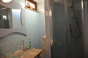 W łazience znajduje się prysznic, umywalka i lustro. w obiekcie FeWo CIELO mit Terrassen und und einen atemberaubenden Blick w mieście Terricciola