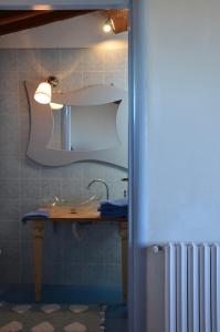 W łazience znajduje się umywalka i lustro. w obiekcie FeWo CIELO mit Terrassen und und einen atemberaubenden Blick w mieście Terricciola