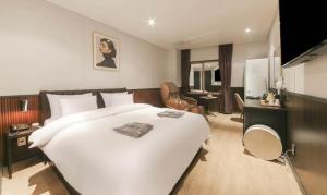Schlafzimmer mit einem großen weißen Bett und einem Schreibtisch in der Unterkunft Incheon Browndot Hotel Nonhyeon Soraepogu in Incheon