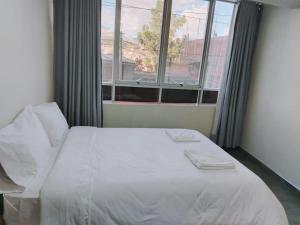 a bed in a room with a large window at ROYALS RESORT in Huaraz