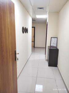 an office corridor with a door and a hallway with clocks on the wall at New! Relaxing Family Home just 8 mins to waterfront in Sharjah