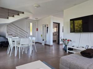uma sala de estar branca com uma mesa e cadeiras em Vera - Luxury Seafront Apartment em Klenovica
