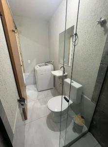a bathroom with a toilet and a glass shower at Flat completo Aparecida de Goiânia in Aparecida de Goiania