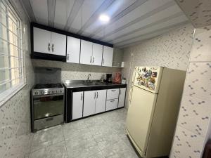 a small kitchen with a refrigerator and a sink at Villa del Centro in Paipa