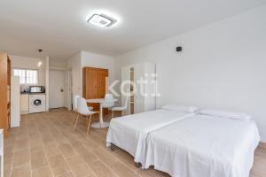 a white bedroom with a white bed and a table at Koti Rentals - Benavente Loft in Fuengirola