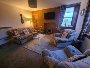 a living room with two couches and a table at Machair House in Iona