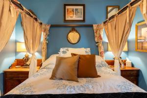 una camera con letto a baldacchino e pareti blu di Palazzo Hudson - Luxury Pool, Hot Tub, and Sauna a Hudson