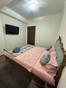 1 dormitorio con 1 cama grande y TV en la pared en Renthouse Apartments - Feel Like Home, en Chişinău