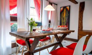 a dining room with a wooden table and red chairs at Ferienwohnungen Kehne - Alte Schneiderei in Bodenwerder