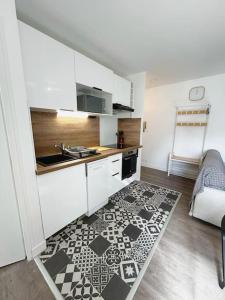 een keuken met een zwart-witte vloer bij Appartement cosy avec terrasse et parking, 4 pers. in Étampes