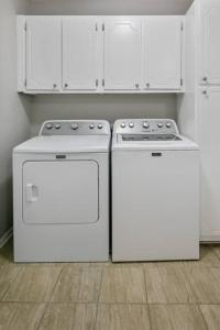 two white appliances in a kitchen with white cabinets at Mesa Manor in Fayetteville
