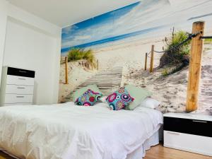 a bedroom with a bed with a mural of a beach at ¡VIVA VIGO! Tu escapada perfecta in Vigo