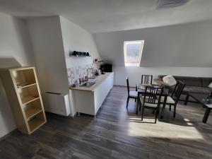 uma cozinha e uma sala de estar com mesa e cadeiras em WHS Apartments em Monostorapáti