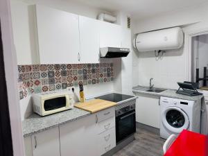 a small white kitchen with a microwave and a stove at ¡VIVA VIGO! Tu escapada perfecta in Vigo