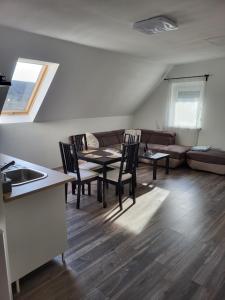 uma sala de estar com uma mesa e cadeiras e um sofá em WHS Apartments em Monostorapáti