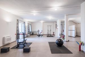 una habitación con un gimnasio con equipamiento de ejercicio. en Agriturismo Corte Benedetto, en Montecarlo