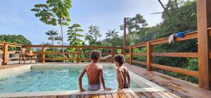 two people sitting in a hot tub on a deck at Pousada Encontro das Águas in Trindade