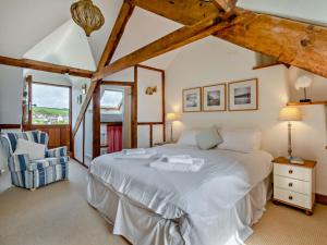 Torcrossにある3 Bed in Torcross 93956のベッドルーム(大きな白いベッド1台、椅子付)