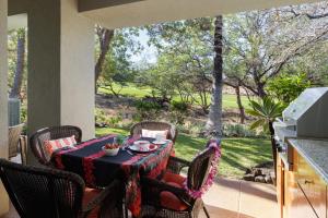 a table and chairs on a patio with a view at Fairways at Mauna Lani #203 in Waikoloa