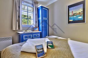 a bedroom with a bed with a blue door at LocaLise - A18 - Appartement avec balcon - Petite vue mer à travers le palmier - Piscine de avril à septembre - Wifi inclus - Animaux admis - Draps inclus - Parking inclus in Le Guilvinec