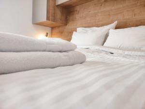 Cama blanca con sábanas y almohadas blancas en MARTINUS-S SVETI MARTIN en Sveti Martin na Muri