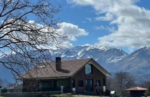 a house with a roof with mountains in the background at Villa los corzos in Oviedo