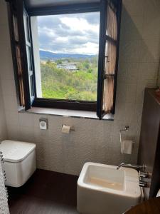 baño con ventana, aseo y lavamanos en Apartamentos Viavelez, en La Caridad