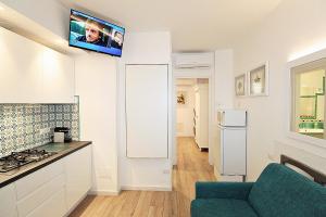 a kitchen with a couch and a tv on the wall at Casa Vacanze del Vicario in San Benedetto del Tronto