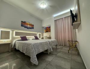 トロペアにあるB&B Holiday Tropeaのベッドルーム1室(紫色の枕が付いたベッド1台付)