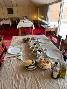 a table with plates of food on top of it at Erg Chebbi Sahara Camp in Merzouga