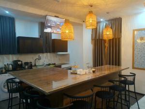 uma cozinha com um grande bar de madeira com bancos em Elite Capsule Hotel em Balkhash