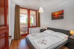 sypialnia z białym łóżkiem i oknem w obiekcie Sekli Apartman w mieście Balatonlelle