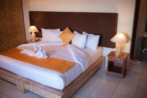 a bedroom with a bed with a stuffed animal on it at Bungalow Geringsing in Candidasa